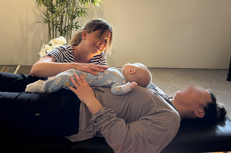 Osteopath treating mother and child together